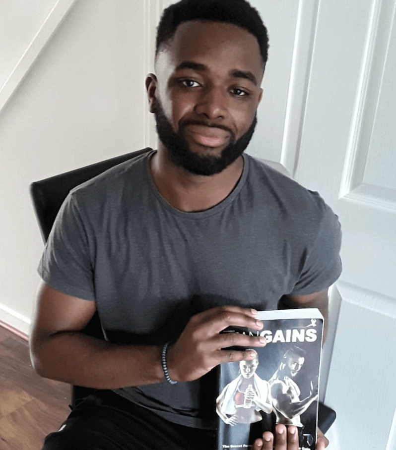 man holding lean gains fitness book